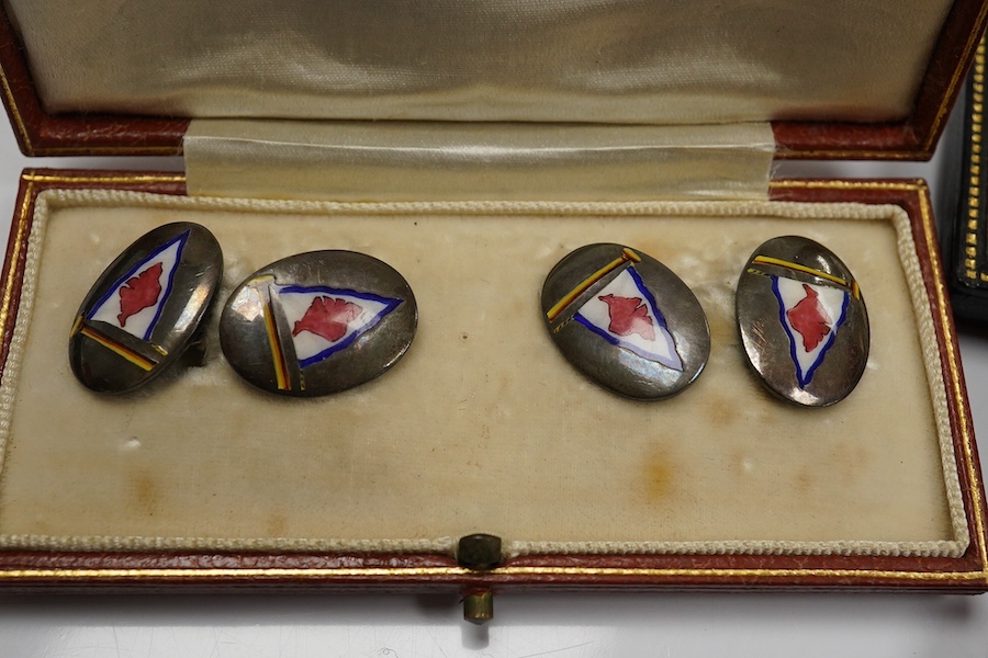 A cased pair of mid 20th century white metal and polychrome enamel oval cufflinks, by Benzies of Cowes, decorated with a pennant, together with five 9ct dress studs and a cased eight piece 9ct and enamel dress stud set.